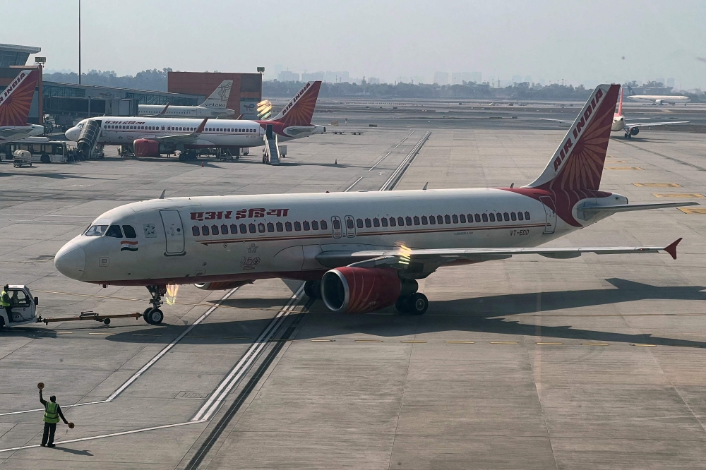 This file photo taken on January 20, 2023 shows an Air India aircraft on the tarmac at the Indira Gandhi International airport in New Delhi. - Air India will buy 250 aircraft from Airbus in a deal aimed at transforming the former national carrier and expanding its operations, chairman announced on February 14, 2023. (Photo by Sajjad HUSSAIN / AFP)
