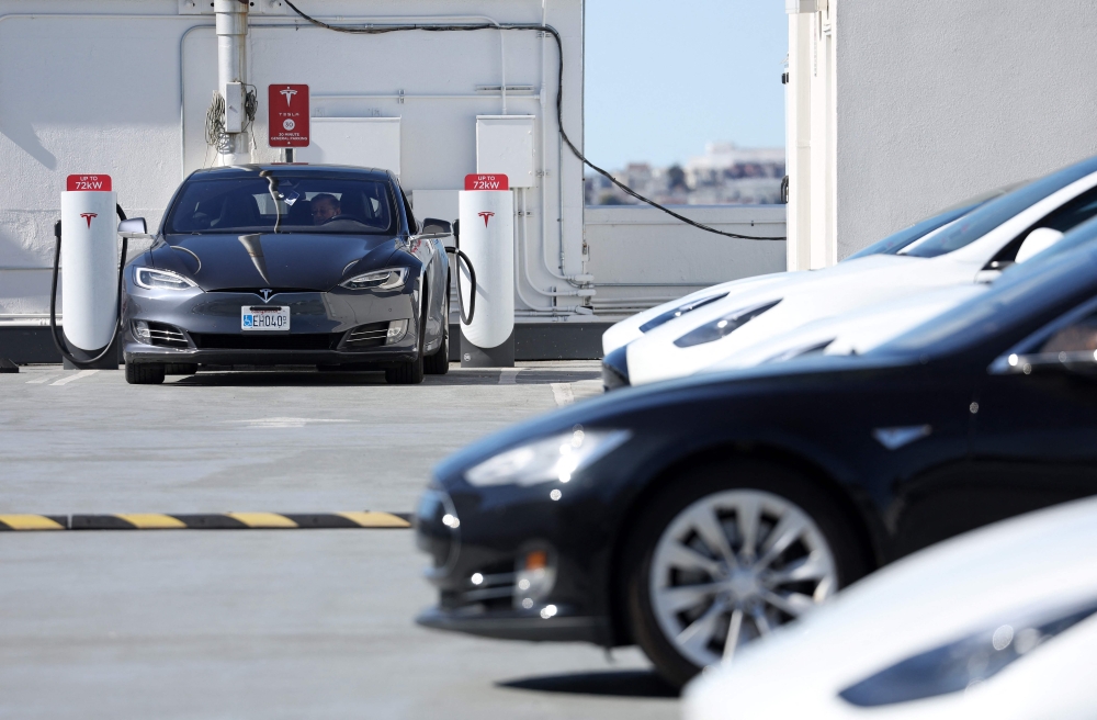 Tesla cars recharge at a Tesla Supercharger station on February 15, 2023 in San Francisco, California. Electric car company Tesla is partnering with the U.S. federal government to expand electric vehicle charging infrastructure in the United States.  Justin Sullivan/Getty Images/AFP 
