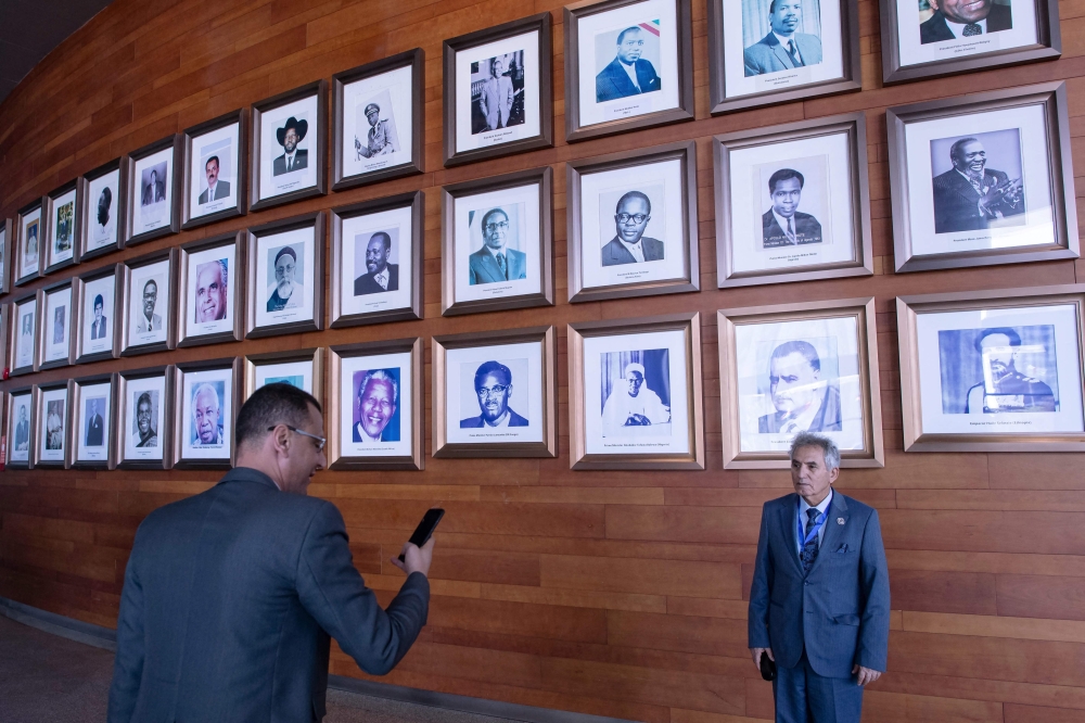 Delegates take pictures at a display of portraits of former Organisation of African Unity (OAU), currently African Union, chairpersons on the second day of the 36th Ordinary Session of the Assembly of the African Union (AU) at the Africa Union headquarters in Addis Ababa on February 19, 2023. (Photo by Tony KARUMBA / AFP)