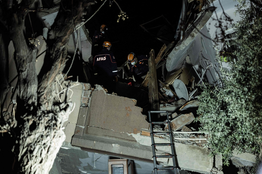 Rescue workers search for victims at a collapsed building after a 6.4-magnitude second earthquake hit the Hatay province in southern Turkey, in Antakya, on February 20, 2023, two weeks after a 7.8-magnitude one hit the first time the same region. (Photo by Sameer Al-Doumy / AFP)