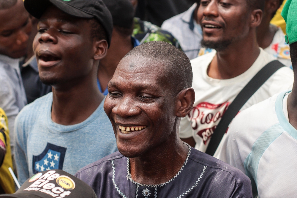 Supporters of the All Progressives Congress (APC) party react while attending their final rally at the Teslim Balogun Stadium in Lagos on February 21, 2023, ahead of the Nigerian presidential election scheduled for February 25, 2023. (Photo by Samuel Alabi / AFP)