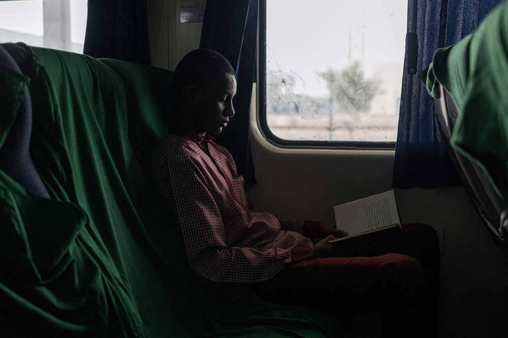 A passenger reads a book on the last train for Kaduna at the Idu Railway Station in Abuja on February 24, 2023, ahead of the Nigerian presidential election scheduled for February 25, 2023. (Photo by Michele Spatari / AFP)