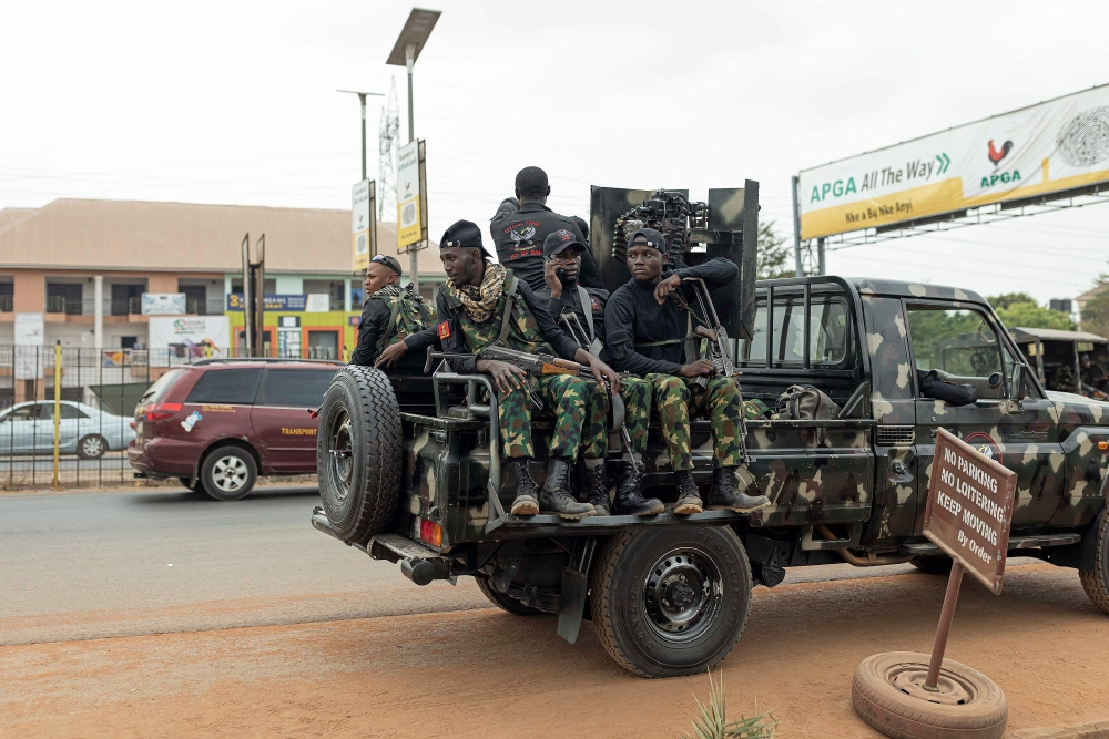 Armed Nigerian army officers sit inside a military vehicle parked outside the Central Bank of Nigeria (CBN) in Awka, Nigeria, on February 24, 2023, ahead of the Nigerian presidential elections scheduled for February 25, 2023. (Photo by Patrick Meinhardt / AFP)
 