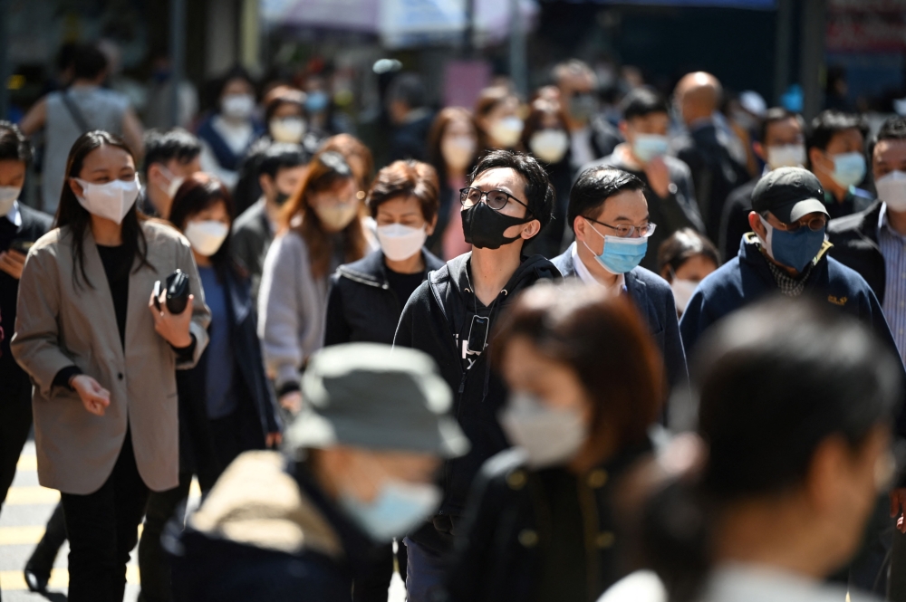 People wear masks on a street in Hong Kong on February 27, 2023 as health experts in the territory backed the extension of its mask mandate to March 8 leaving Hong Kong as one of the only places left in the world with such rules. (Photo by Peter PARKS / AFP)