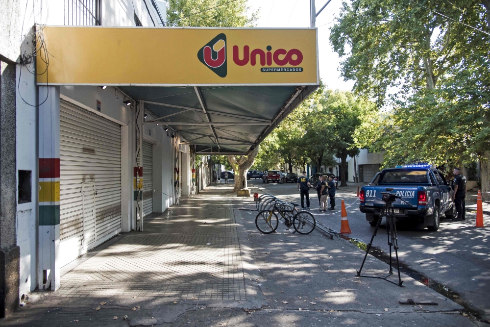 Police inspect a supermarket belonging to the family of Antonela Roccuzzo, the wife of Argentine football star Lionel Messi, after attackers fired shots at the facade of the closed premises early in the morning and left a threat message to Messi, in Rosario, Santa Fe Province, Argentina, on March 2, 2023. - Two men attacked the front of a supermarket belonging to the in-laws of Messi and left a written message mentioning the captain of the world champion Argentine team, the mayor of the city Pablo Javkin said. 