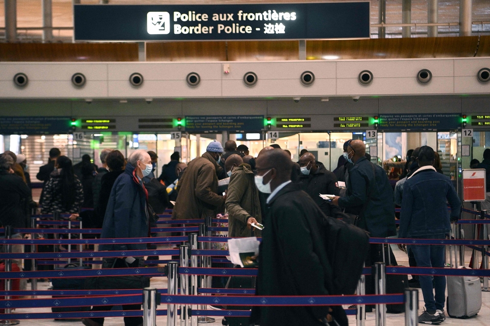 In this file photo taken on February 1, 2021, travellers queue at the immigration desk of Roissy Charles-de-Gaulle international airport in Paris, France.  (Photo by Christophe Archambault / AFP)

