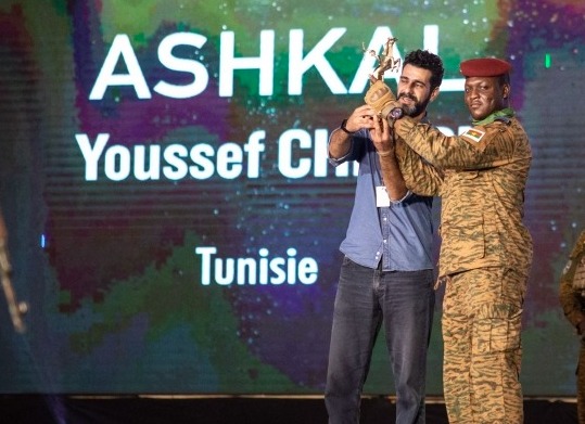 A man (2nd L) representing the Tunisian director Youssef Chebbi, receives from Burkina Faso military leader Captain Ibrahim Traore (3rd L) the Etalon d'Or won for the film 