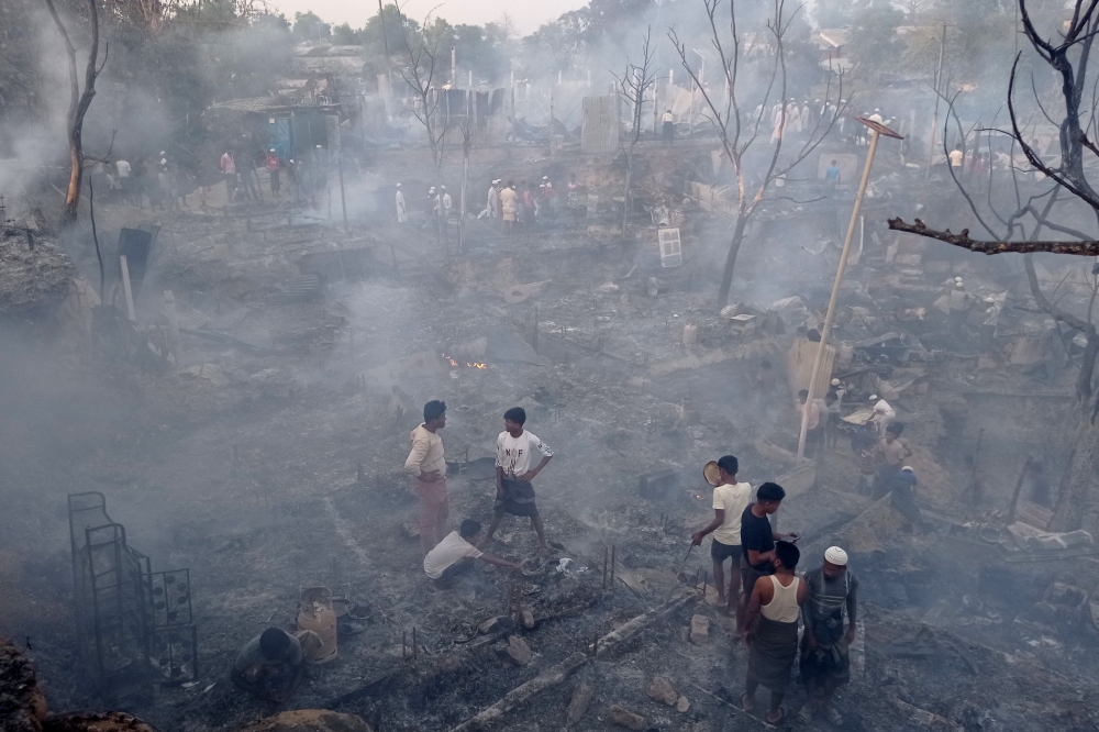 Rohingya refugees search for their belongings after a fire broke out in Balukhali refugee camp in Ukhia on March 5, 2023. (Photo by Tanbir Miraz / AFP)
 