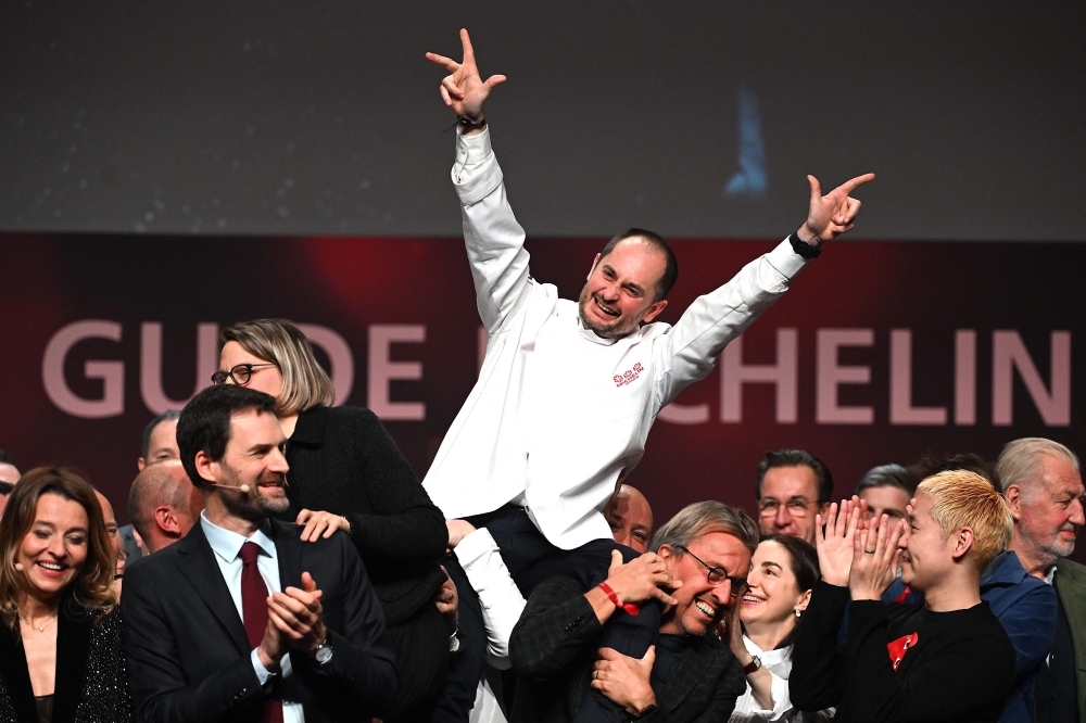 Alexandre Couillon celebrates after being awarded a third Michelin star, during the 2023 edition of the Michelin guide awards ceremony on March 6, 2023 in Strasbourg, eastern France. (Photo by PATRICK HERTZOG / AFP)
