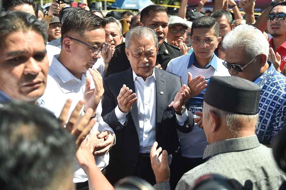 prime minister of Malaysia and Perikatan Nasional (PN) chairman Muhyiddin Yassin (C) arrives at the Malaysian Anti-Corruption Commission (MACC) headquarters to give a statement over allegations that his party misused public funds meant to fight Covid-19 in Putrajaya on March 9, 2023. (Photo by Arif Kartono / AFP)