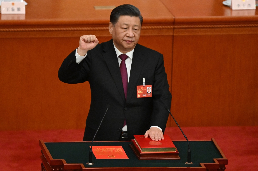 China's President Xi Jinping swears under oath after being re-elected as president for a third term during the third plenary session of the National People's Congress (NPC) at the Great Hall of the People in Beijing on March 10, 2023. (Photo by NOEL CELIS / AFP)
