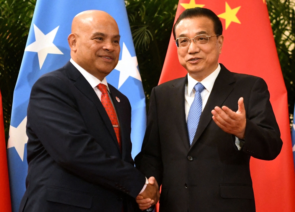 (FILES) This file photo taken on December 13, 2019 shows Micronesia's President David Panuelo (L) with China's Premier Li Keqiang at the Great Hall of the People in Beijing. - Panuelo has accused China of bribery, harassment and 