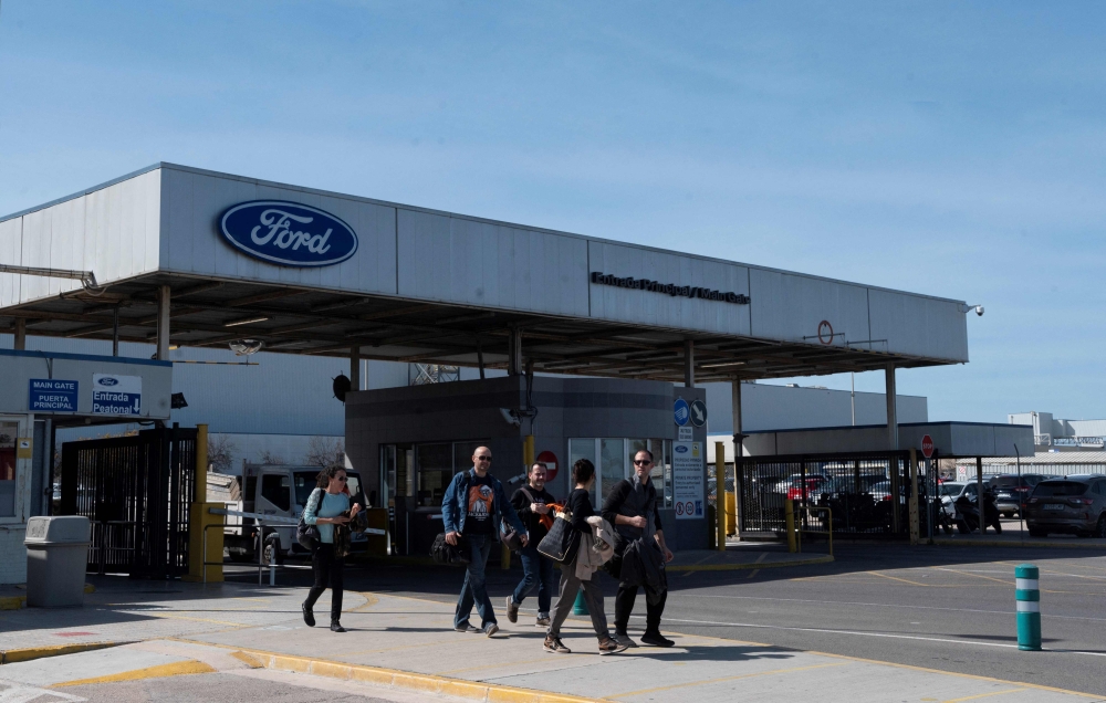 Workers leave the Ford factory in Almussafes near Valencia, on March 10, 2023, after the US carmaker announced it will cut around 1,100 jobs at this factory as it reorganises its operations in Europe. (Photo by JOSE JORDAN / AFP)