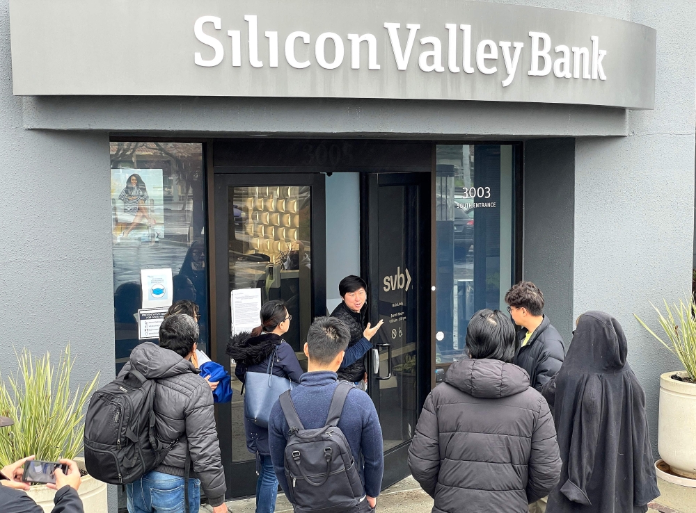 A worker tells people that the Silicon Valley Bank (SVB) headquarters is closed on March 10, 2023 in Santa Clara, California. (Photo by JUSTIN SULLIVAN / Getty Images via AFP)