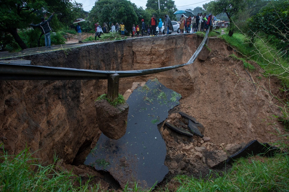 A general view of a collapsed road caused by flooding waters due to heavy rains following cyclone Freddy in Blantyre, Malawi, on March 13, 2013.  (Photo by Amos Gumulira / AFP)
 