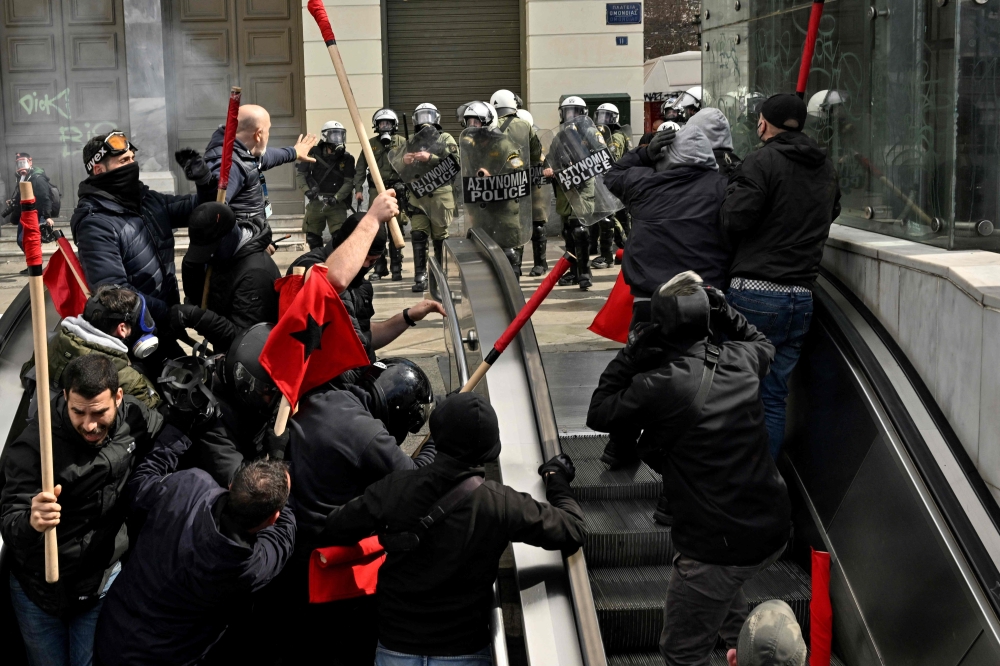 File photo: Protesters run from police into a metro station during a massive demonstration in Athens on March 5, 2023, following the deadly train accident late on February 28. (Photo by Louisa Gouliamaki / AFP)

