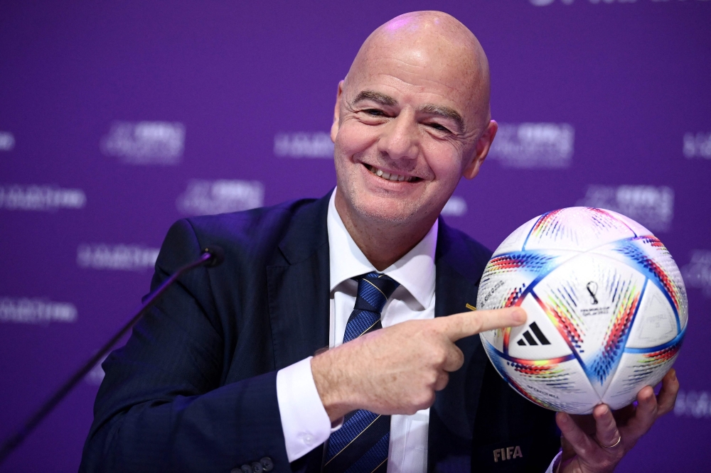 This file photo taken on March 31, 2022 shows FIFA president Gianni Infantino posing with Al Rihla, the official match ball before a press conference during the 72nd FIFA Congress in the Qatari capital Doha. (Photo by FRANCK FIFE / AFP)
