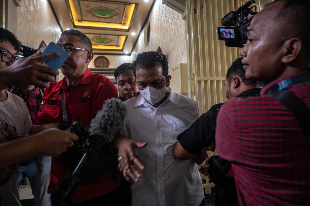 Police officer Hasdarmawan (C) arrives for his trial at a courthouse in Surabaya on March 16, 2023. (Photo by JUNI KRISWANTO / AFP)