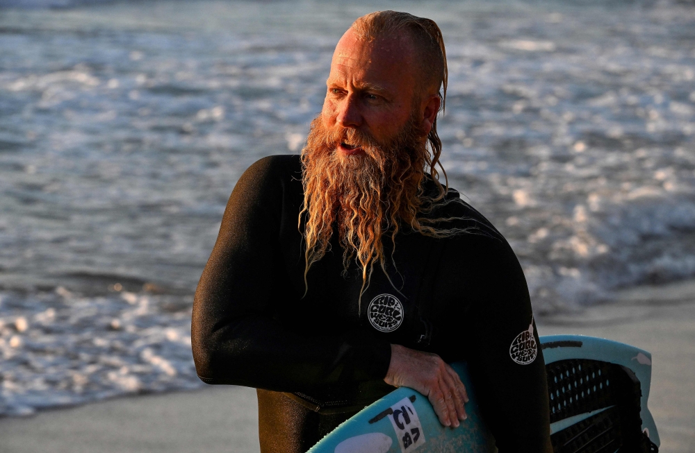 Australian former professional surfer Blake Johnston walks back to shore after breaking the record for the world's longest surf session on Cronulla Beach in Sydney on March 17, 2023. Photo by Saeed KHAN / AFP)