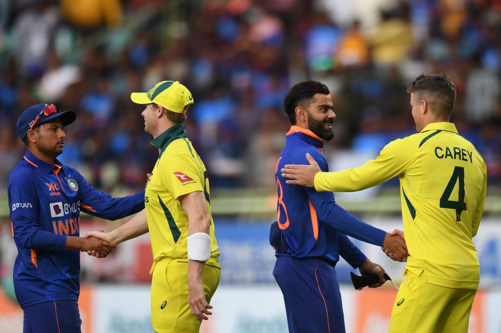 India's Virat Kohli (2R) and Kuldeep Yadav (L) shake hands with Australia's captain Steve Smith (2L) and Alex Carey at the end of the second one-day international (ODI) cricket match between India and Australia at the Y.S. Rajasekhara Reddy Cricket Stadium in Visakhapatnam on March 19, 2023. (Photo by Noah Seelam / AFP)