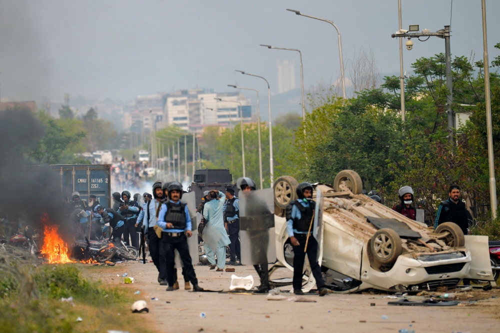 Riot police stand guard outside a court before the arrival of Pakistan's former prime minister Imran Khan, in Islamabad on March 18, 2023. (Photo by Farooq Naeem / AFP)