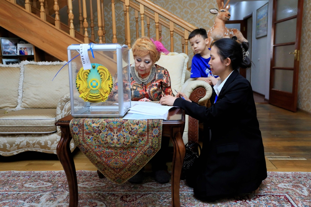 A woman votes at her home during parliamentary elections in Almaty on March 19, 2023. (Photo by Ruslan Pryanikov / AFP)