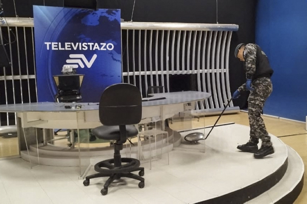Handout photo released by Ecuador's National Police showing a police officer searching for explosives after a device detonated at the Ecuavisa channel premises in Guayaquil, Ecuador on March 20, 2023.  (Photo by Handout / Ecuadorｴs National Police / AFP)