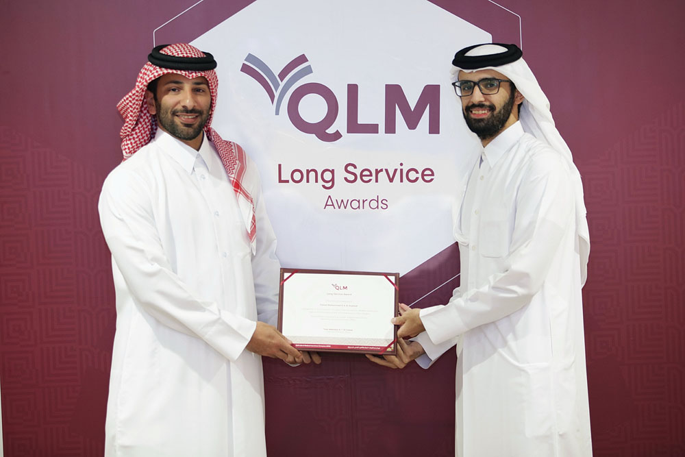 A QLM Life & Medical Insurance Company official presents long service award to an employee.