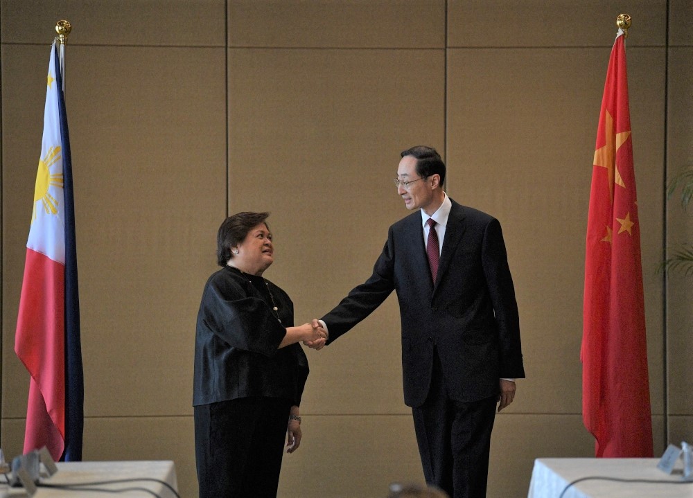 Theresa Lazaro (left), Philippines' Undersecretary for Bilateral Relations and Asian Affairs of the Department of Foreign Affairs, shakes hands with China's Vice Foreign Minister Sun Weidong prior to the start of the Philippines-China Foreign Ministry consultation meeting in Manila on March 23, 2023. (Photo by Ted Aljibe / AFP)