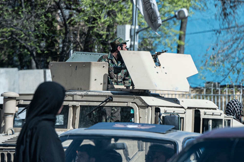 A Taliban security personnel sits on a humvee armored vehicle near the site of a suicide attack in Kabul on March 27, 2023.   (Photo by Wakil KOHSAR / AFP)