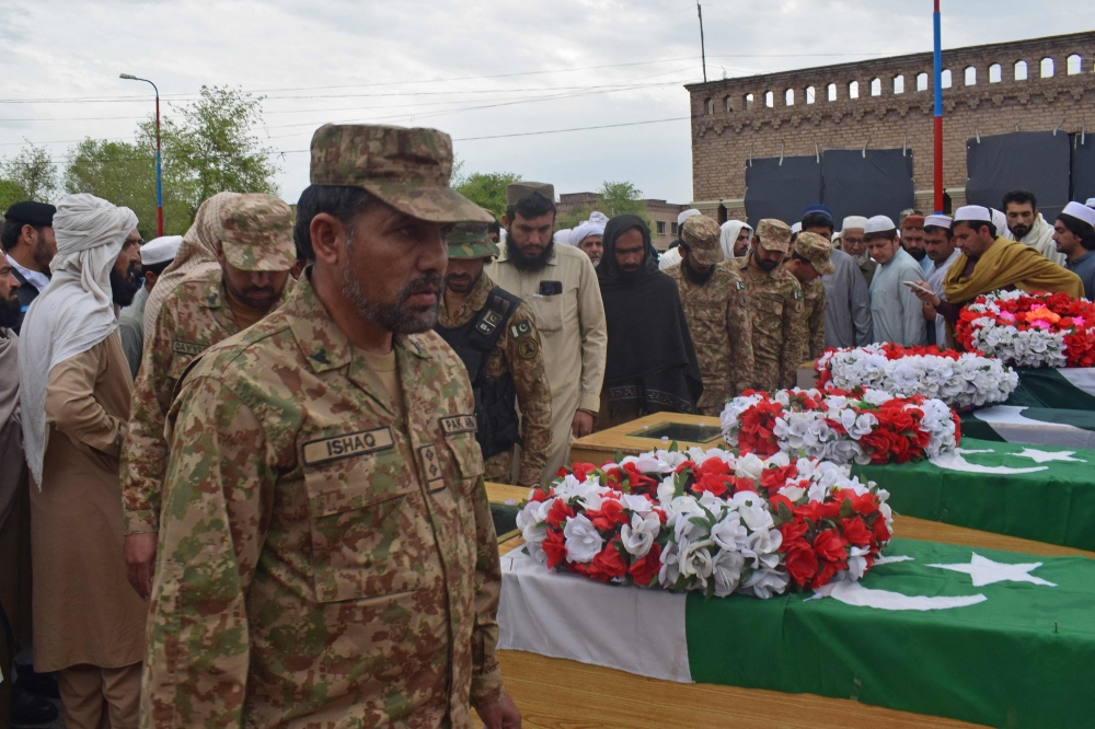 Relatives and security officials gather around the coffins of policemen who were killed by a roadside bomb in Lakki Marwat district of Khyber Pakhtunkhwa province on March 30, 2023.  (Photo by Marwat AKBAR / AFP)