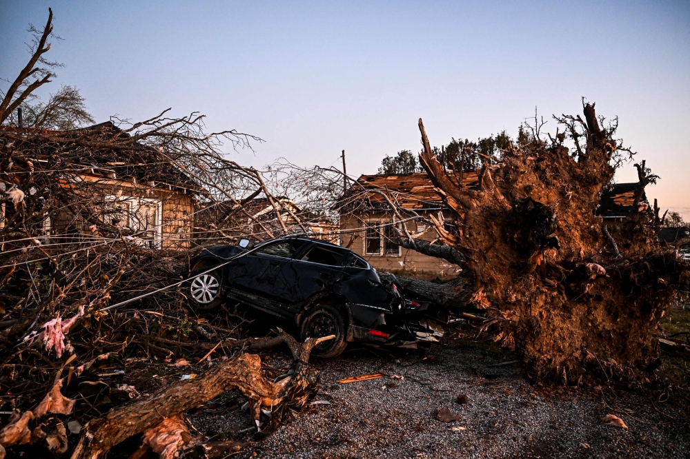 The remains of a house and cars are entangled in tree limbs in Rolling Fork, Mississippi, on March 25, 2023, after a tornado touched down in the area. Photo by Chandan Khanna / AFP

