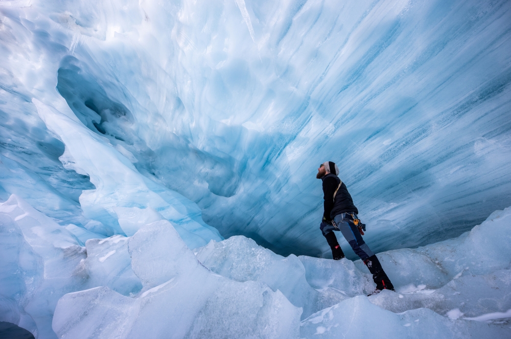 File Photo: Glaciologist Martin Stocker-Waldhuber from the Austrian Academy of Sciences explores a natural glacier cavity of the Jamtalferner glacier near Galtuer, Austria, October 15, 2021. 