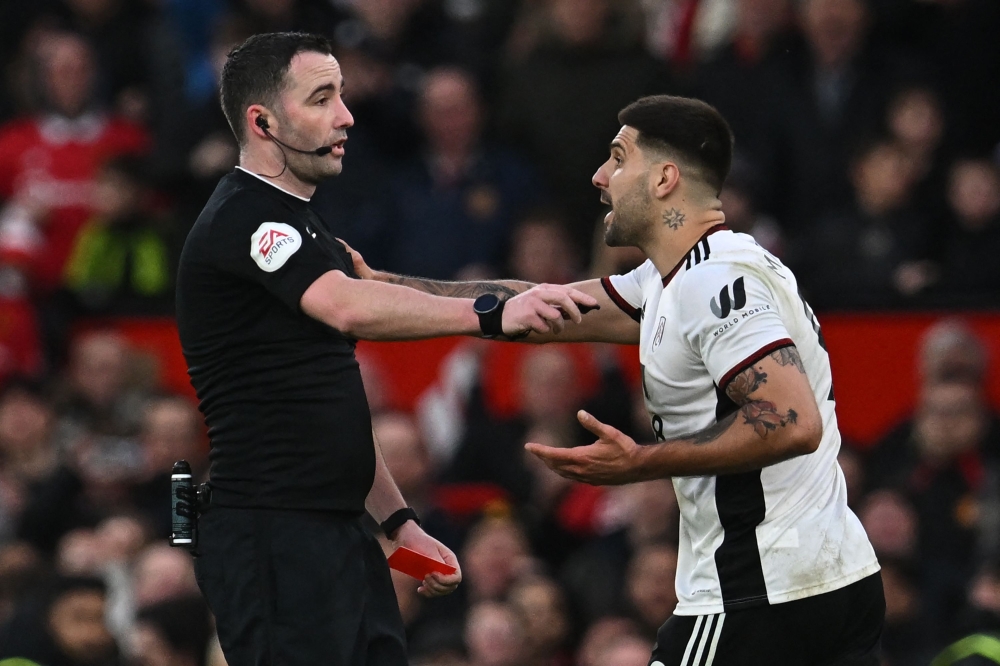 In this file photo taken on March 19, 2023 Fulham's Serbian striker Aleksandar Mitrovic (R) argues with English referee Chris Kavanagh (L) and gets himself sent off during the English FA Cup quarter-final football match between Manchester United and Fulham at Old Trafford in Manchester, north-west England. (Photo by Paul ELLIS / AFP) 