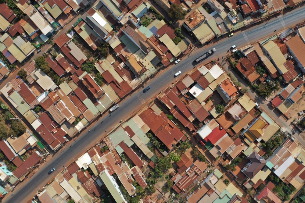 This aerial photograph taken on April 5, 2023 shows red dust on rooftops of communities near the construction site of Long Thanh airport in Dong Nai province. Photo by Nhac NGUYEN / AFP