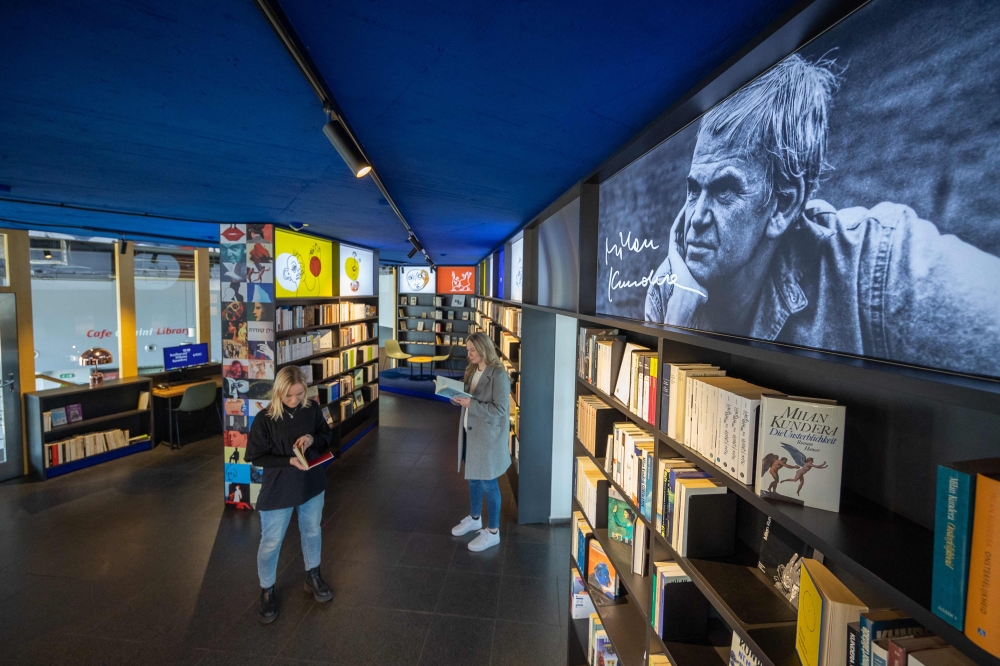 Visitors to the Milan Kundera library in Brno, Czech Republic read books by the Czech novelist on April 6, 2023. Photo by Radek Mica / AFP
