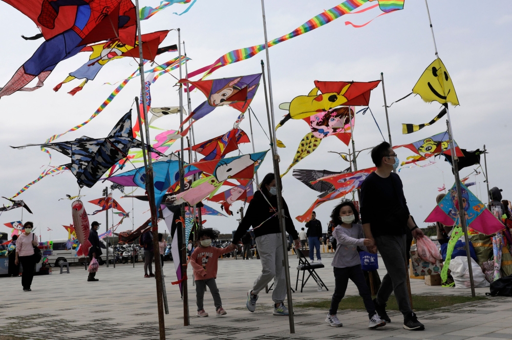 People walk past vendors selling kites at Hsinchu fishing port on April 9, 2023. (Photo by Jameson Wu / AFP)