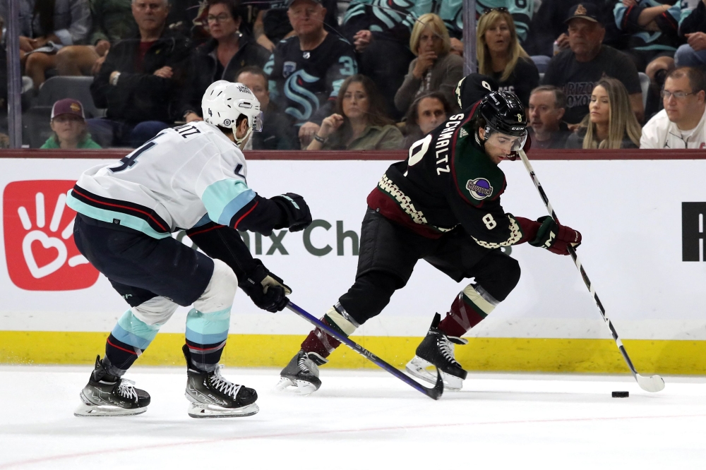Nick Schmaltz #8 of the Arizona Coyotes skates the puck against Justin Schultz #4 of the Seattle Kraken during the second period at Mullett Arena on April 10, 2023 in Tempe, Arizona. Photo by Zac BonDurant / GETTY IMAGES NORTH AMERICA / Getty Images via AFP