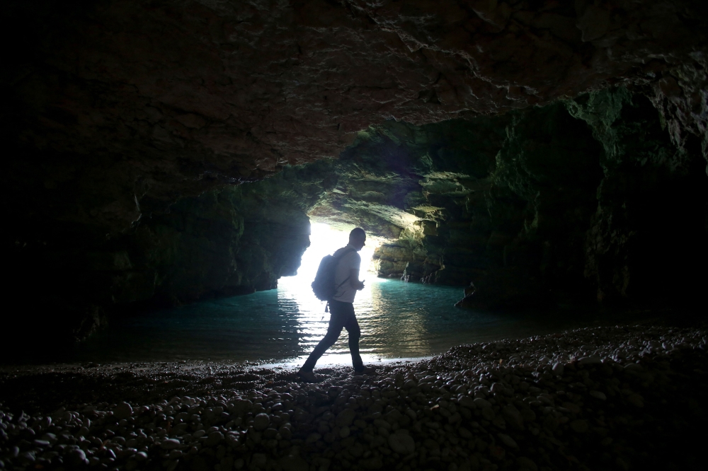 Nexhip Hysolokaj, a biodiversity expert, installs a camera trap inside a cave, a habitat used by Mediterranean monk seals (Monachus monachus), at the Karaburun peninsula, some 17.5 nautical miles from the coast of Vlore, southern Albania, on March 24, 2023. Photo by Adnan Beci / AFP
