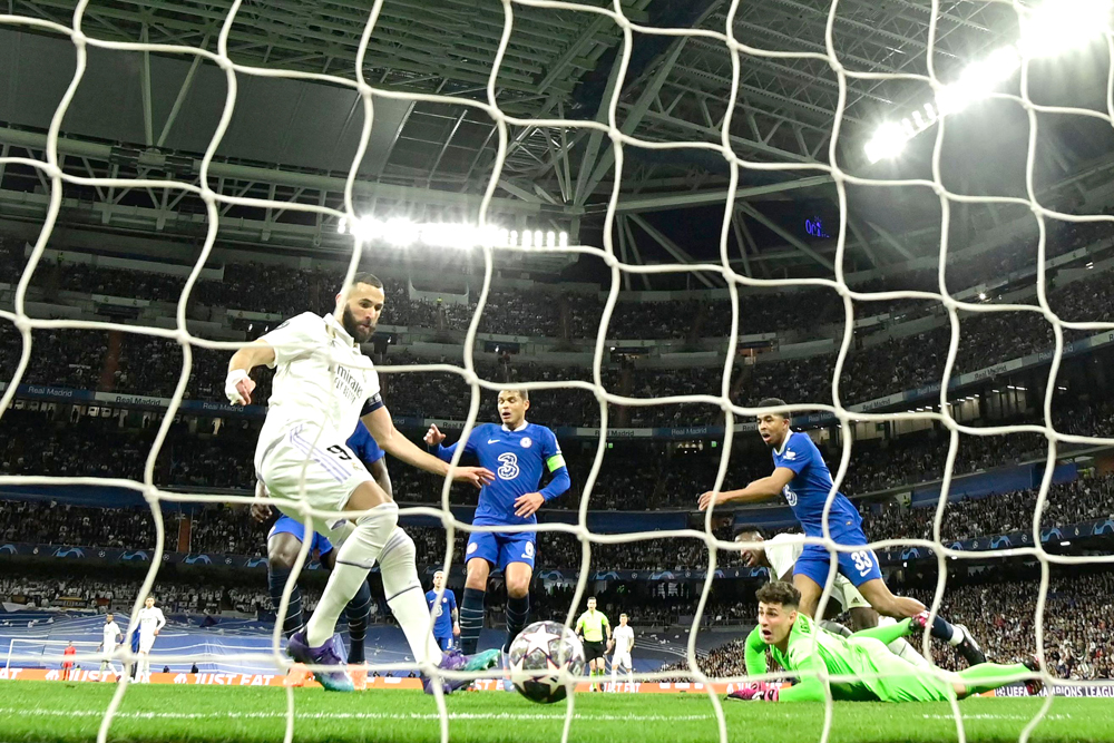 Real Madrid’s Karim Benzema (left) scores his team’s first goal against Chelsea yesterday. AFP