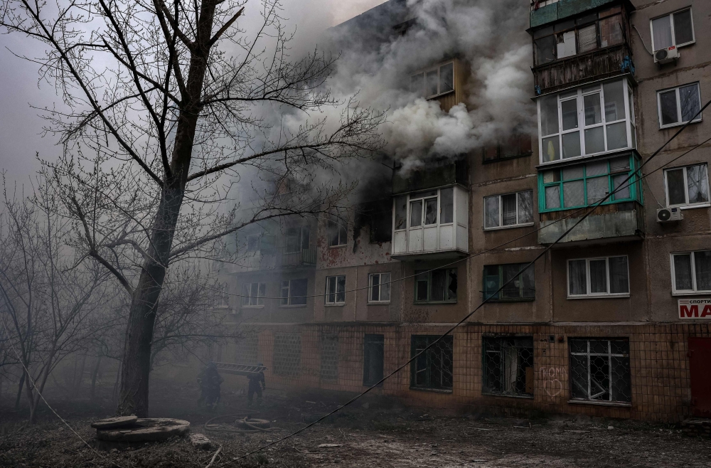 Firefighters work at a site of a burning residential building, after shelling in Sloviansk, on April 14, 2023.  Photo by ANATOLII STEPANOV / AFP
