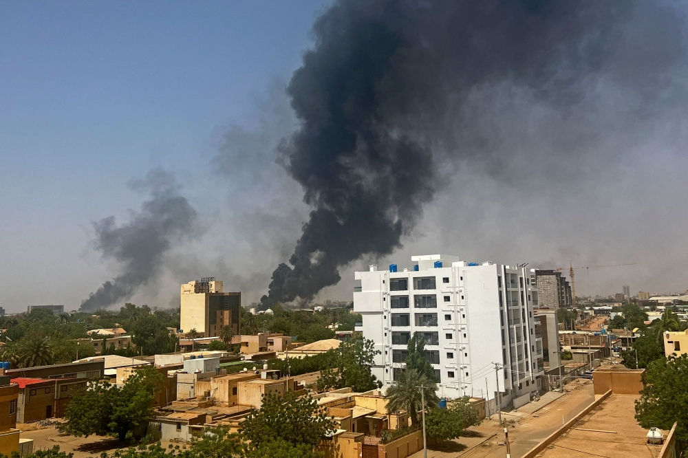 Smoke billows above residential buildings in Khartoum on April 16, 2023, as fighting in Sudan raged for a second day in battles between rival generals. (Photo by AFP)