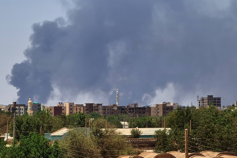 Smoke billows over buildings in Khartoum on May 1, 2023 as deadly clashes between rival generals' forces have entered their third week. Photo by AFP