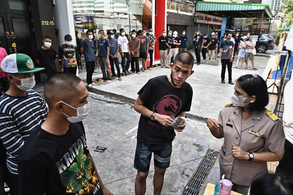 Thai army personnels in plain clothes wait in a queue to cast their ballot at a polling station during Thailand general election in Bangkok on May 14, 2023. Photo by Lillian SUWANRUMPHA / AFP