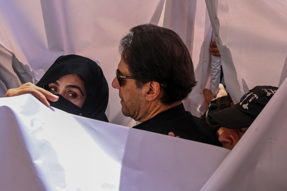 Former Pakistan prime minister Imran Khan with his wife Bushra Bibi arrive to appear at a high court in Lahore on May 15, 2023. (Photo by Arif Ali / AFP)