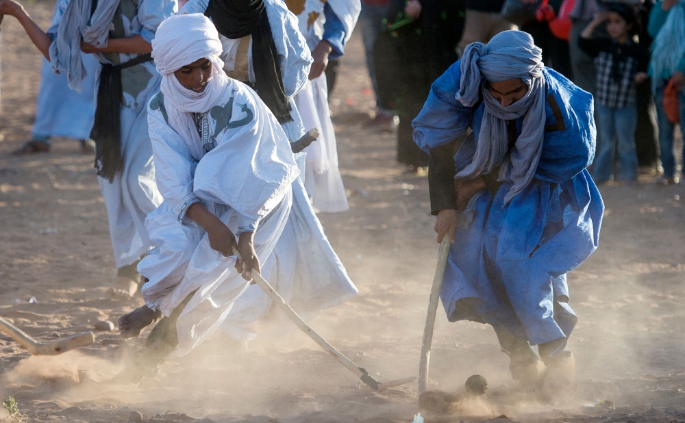 Locals play hockey during the 15th International Nomad Festival in Mhamid el-Ghizlane in Morocco's southern Sahara desert on March 24, 2018. (Photo by Fadel Senna / AFP)
