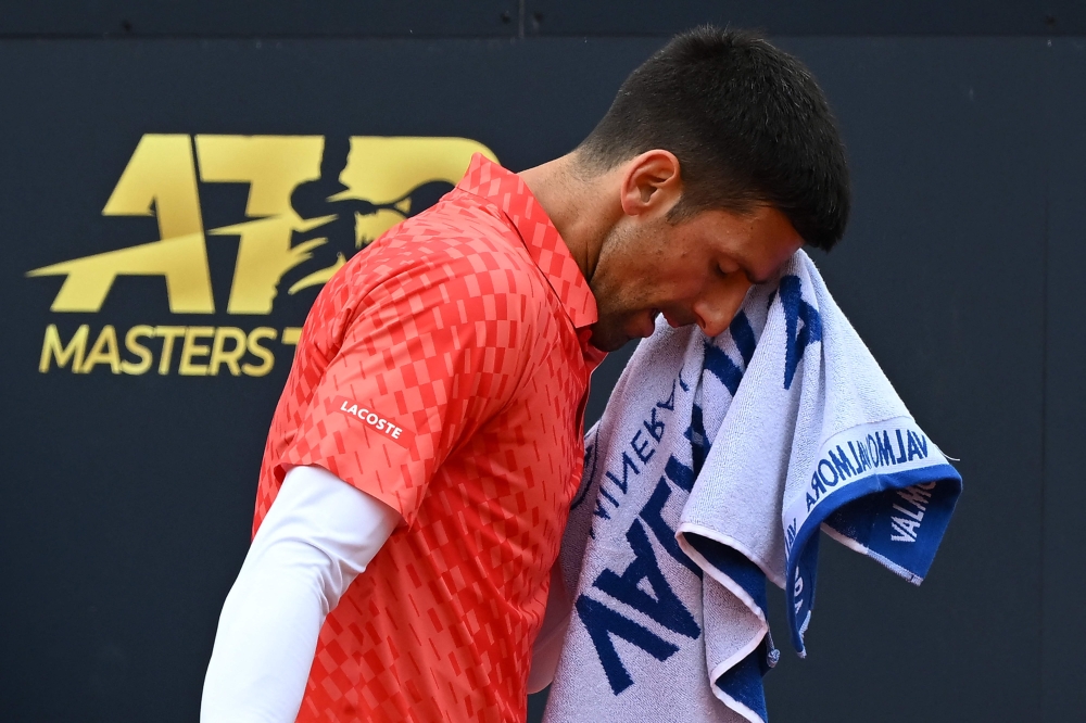 Serbia's Novak Djokovic wipes his face during his quarterfinals match of the Men's ATP Rome Open tennis tournament against Denmark's Holger Rune, at Foro Italico in Rome on May 17, 2023. (Photo by Filippo MONTEFORTE / AFP)
