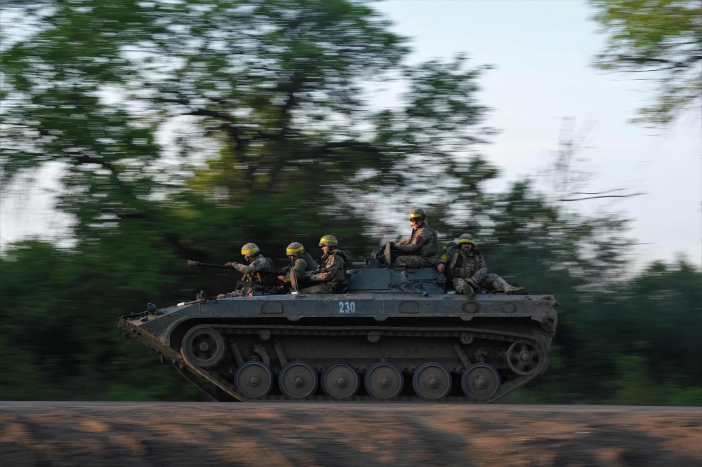 Ukrainian soldiers ride on a BMP infantry fighting vehicle toward Bakhmut, on May 20, 2023, amid the Russian invasion of Ukraine.  Photo by Sergey SHESTAK / AFP
