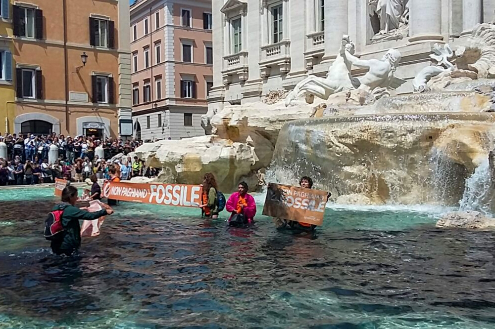 A photo taken and issued as a handout on May 21, 2023 by environmental activists of Last Generation (Ultima Generazione) shows the group's activist holding a banner reading 