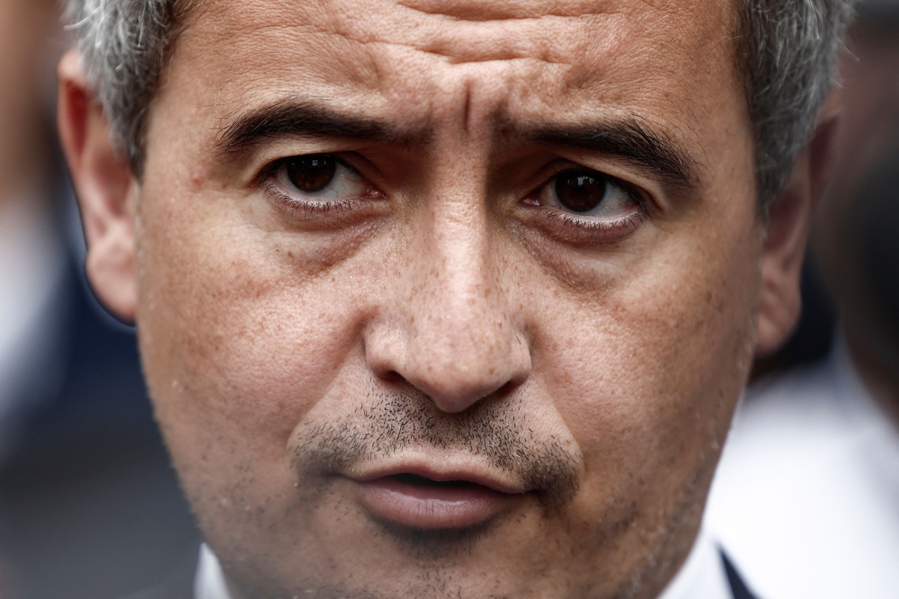French Interior Minister and Overseas Gerald Darmanin (C) delivers remarks to journalists outside at a police station after paying tribute to three police officers from the precinct killed in a road traffic accident one day prior, in Roubaix, northern France, on May 23, 2023. Photo by Sameer Al-Doumy / AFP